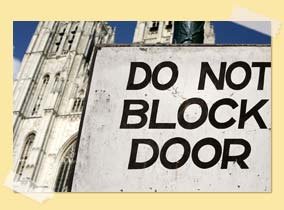 Image of a church with "do not block door" sign
